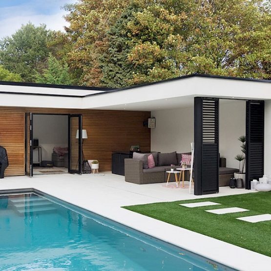 Pool house avec salon elegant au bord d'une piscine