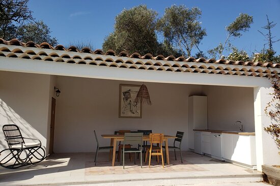 Pool house avec cuisine d'été intégrée et chaises en bois