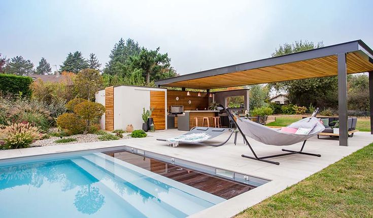 Pool house avec cuisine d'été et un coin détente au bord de la piscine
