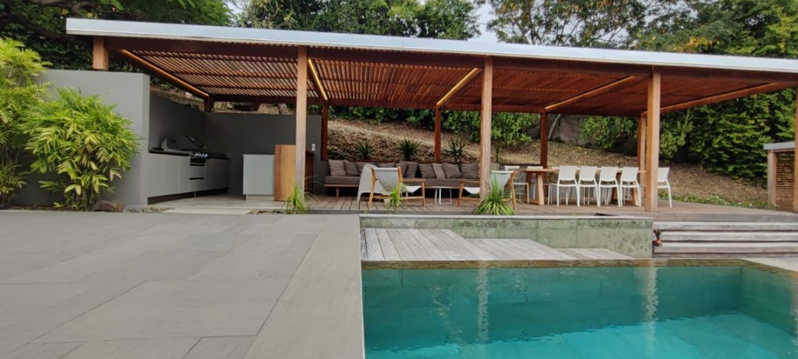 Pool house moderne avec cuisine d'été intégrée et terrasse extérieure