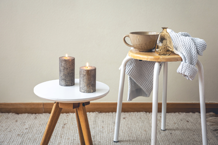 Décor scandinave cocooning avec bougies et petites tables rondes en bois.