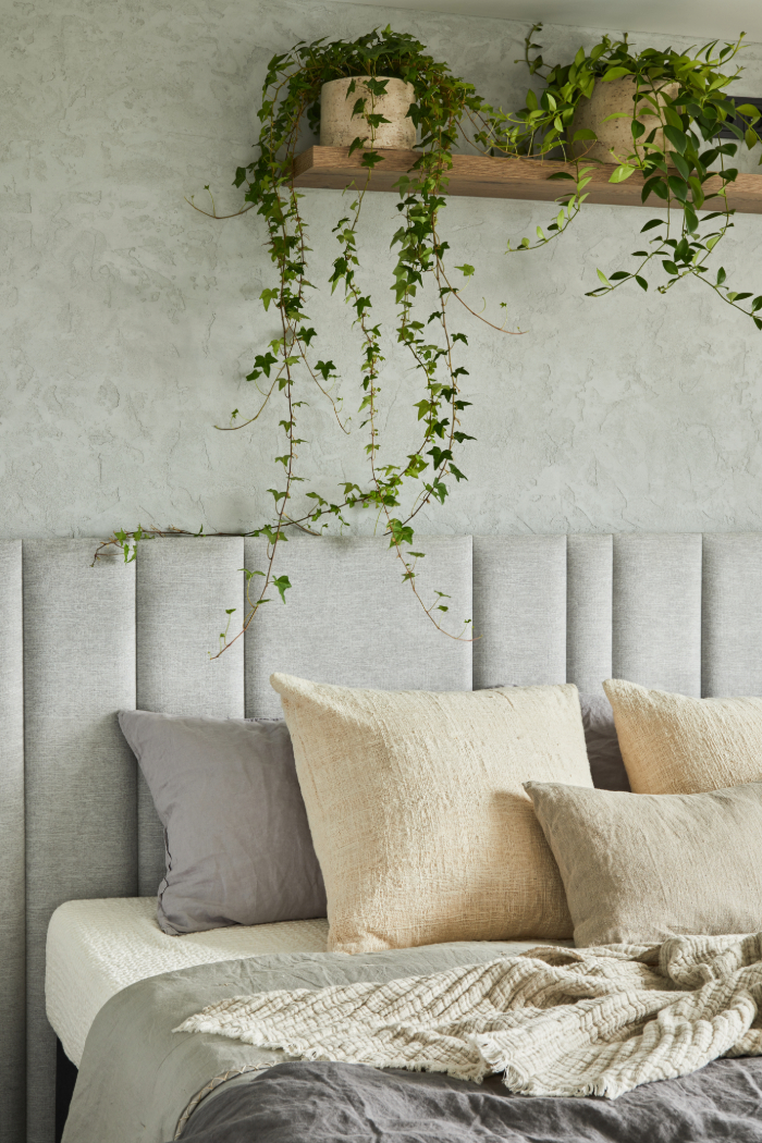 Décoration d'une chambre zen et naturelle avec des tons neutres et plantes suspendues.