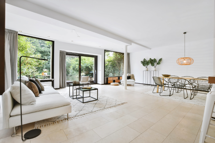 Décoration maison neuve moderne avec couleurs neutres, plantes vertes, tapis doux, suspension naturelle et mobilier minimaliste.