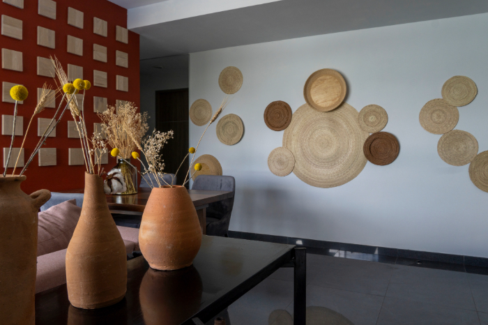 Pièce décorée avec vases en terre cuite, fleurs séchées, mur orné de paniers tressés.