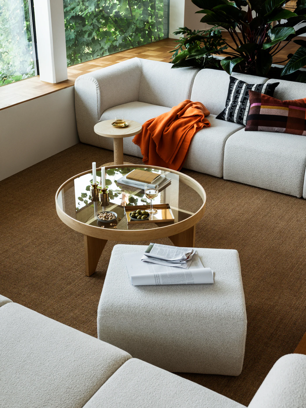 Salon simple avec meubles au design minimaliste : canapé blanc, table en bois et coussins colorés.