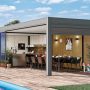 Pool house avec cuisine d'été incluant une grande table à manger noire, des chaises assorties, un bardage bois, une pergola grise, des plantes décoratives, un jouet enfant et un parquet en bois.