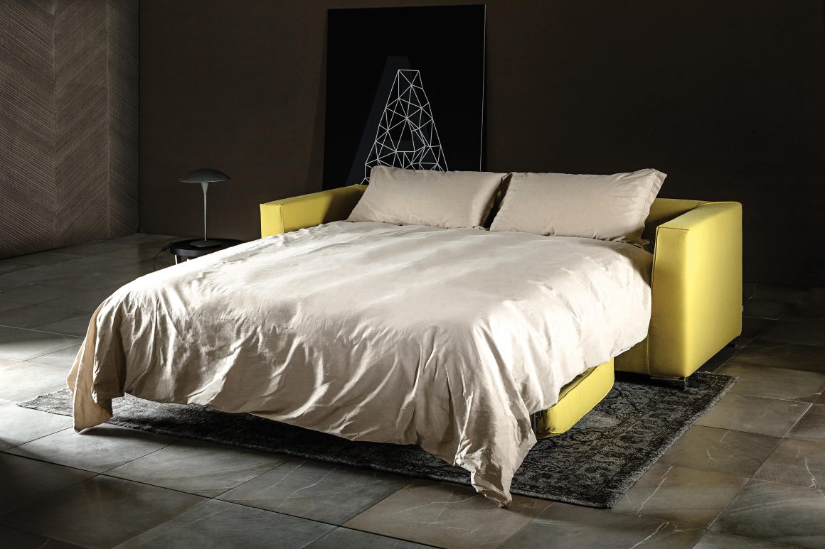 Espace minimaliste incluant un canapé convertible jaune.