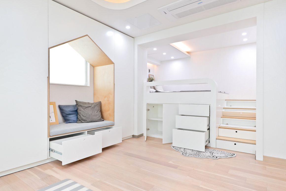 Chambre moderne avec lit mezzanine et espace de rangement.