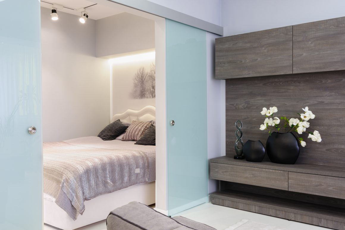 Chambre cosy avec lit, portes coulissantes, déco florale noire et meubles modernes bois.