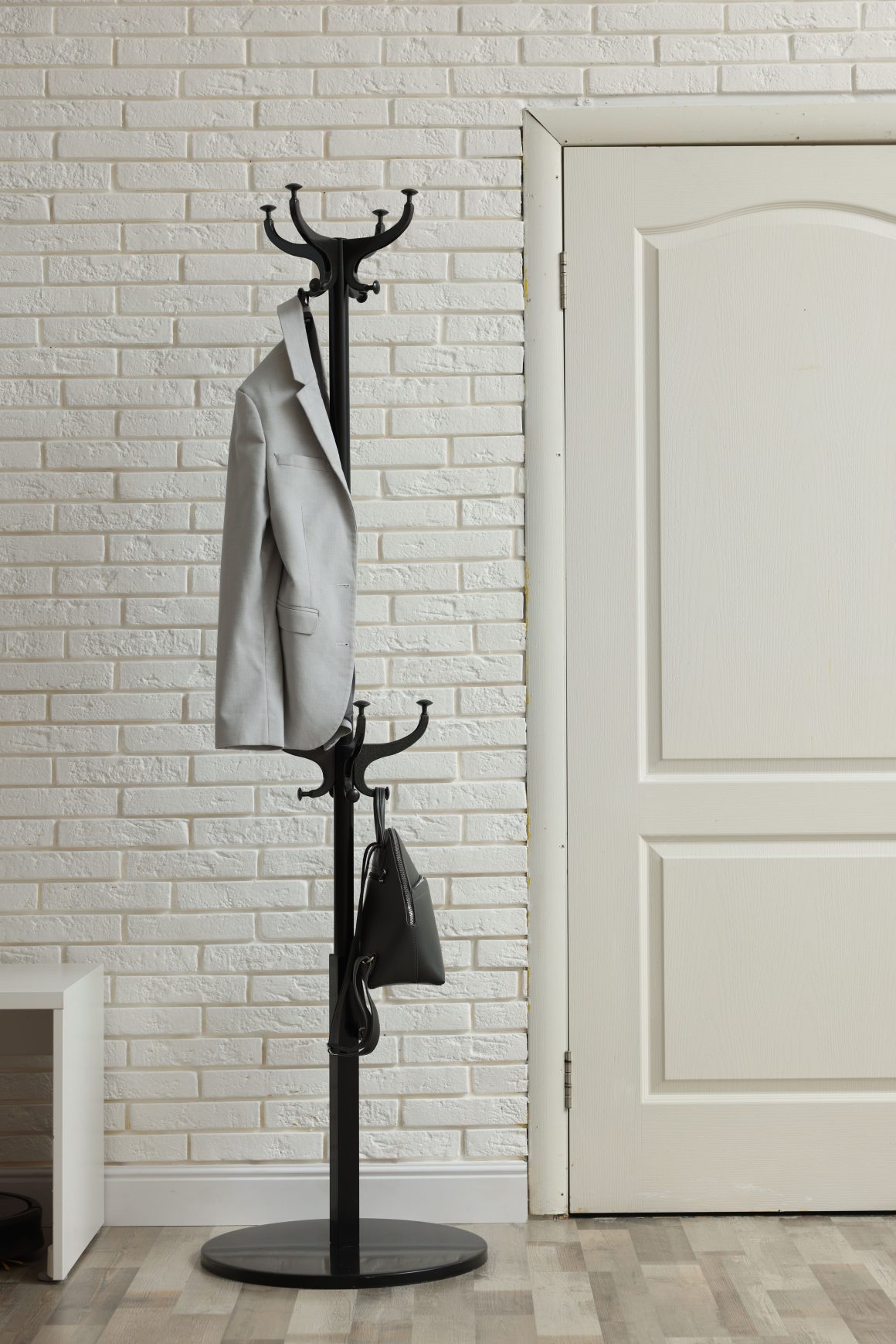 Portemanteau sur pied placé dans une entrée maison minimaliste.