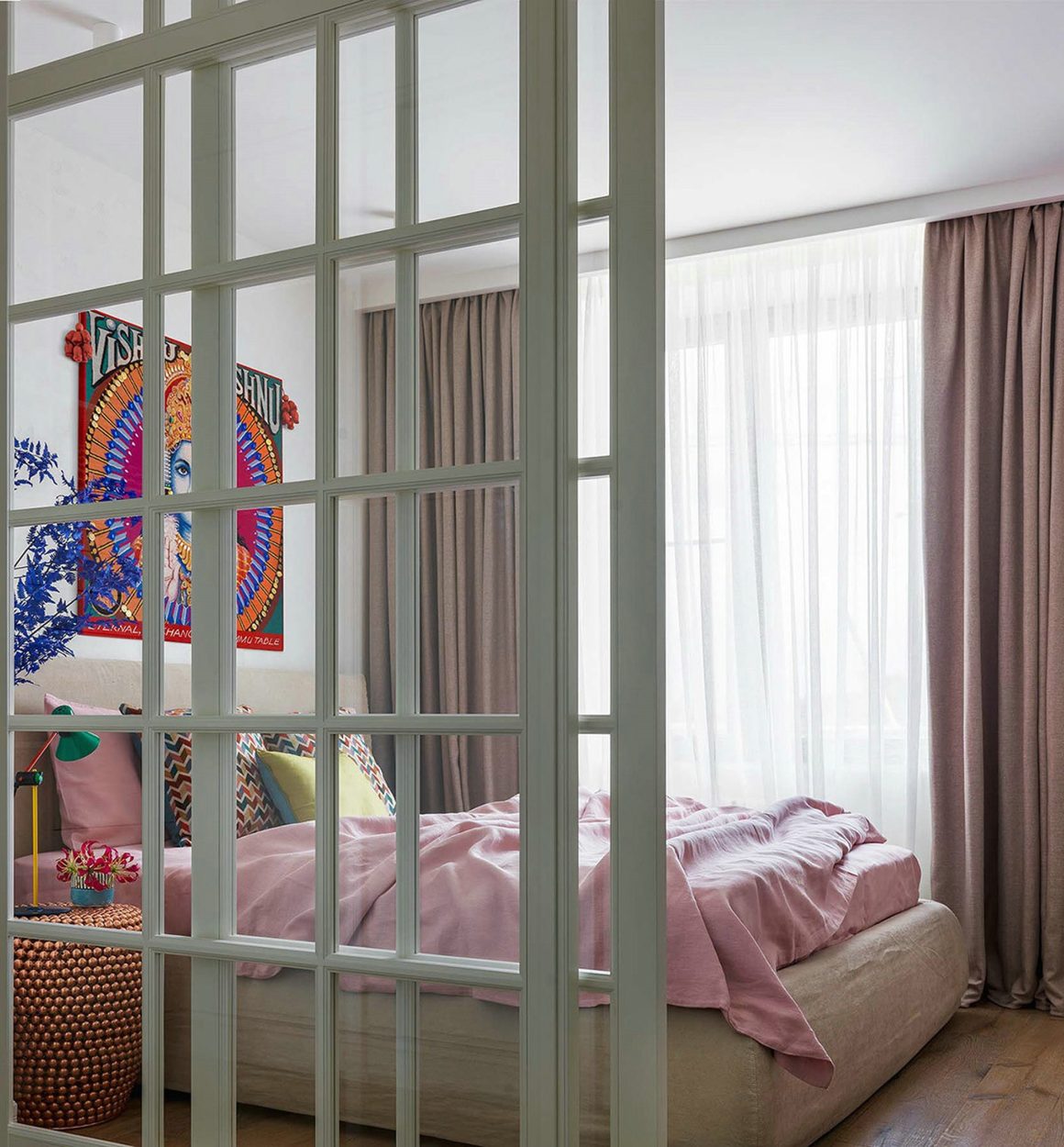 Chambre moderne avec séparation en verre, lit, rideaux, décoration colorée.