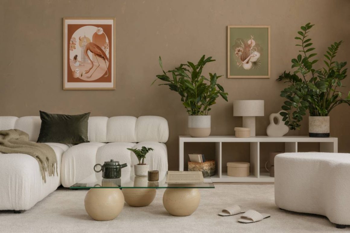 Salon moderne incluant canapé blanc doux, table verre ronde, plantes vertes et tableaux artistiques.