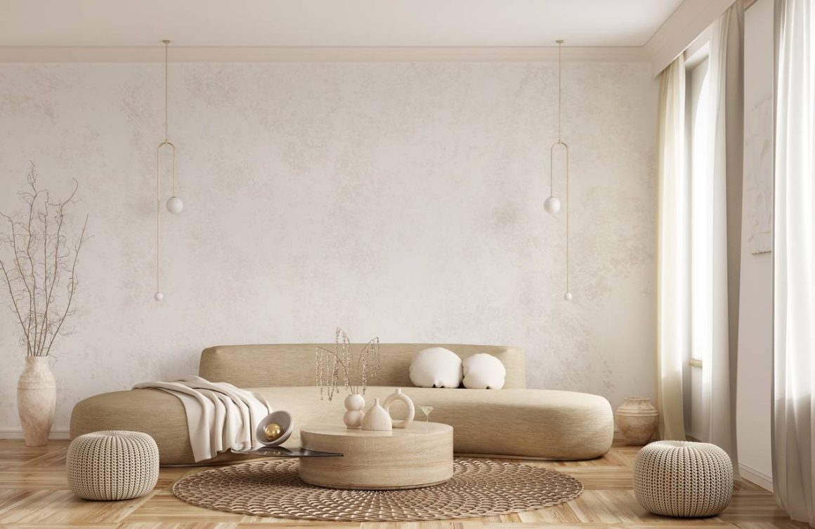 Canapé arrondi dans un salon minimaliste avec table basse, tapis rond et rideaux légers.