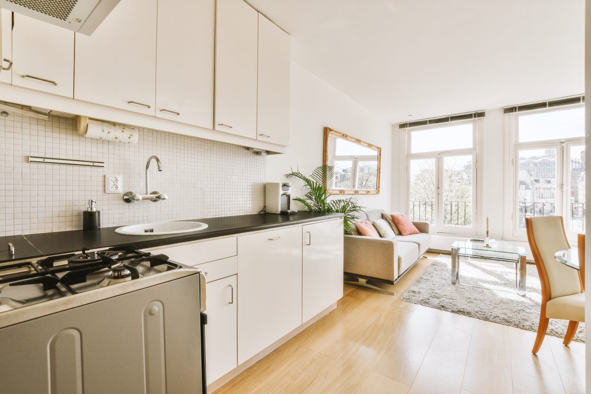 Aménagement d'une cuisine 4m2 ouverte sur salon avec placards jusqu'au plafond et des rangements au-dessous de l'évier.