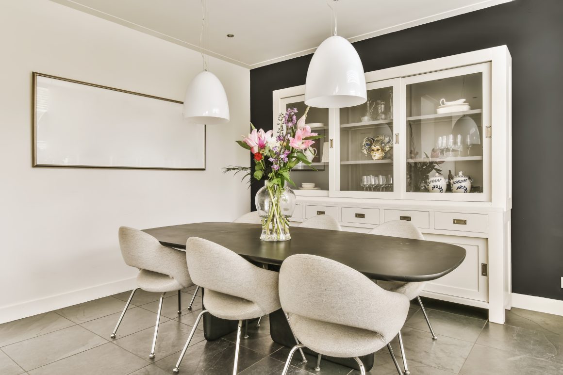 Idées de décoration salle à manger avec luminaires modernes, vase de fleurs et mobilier sobre.