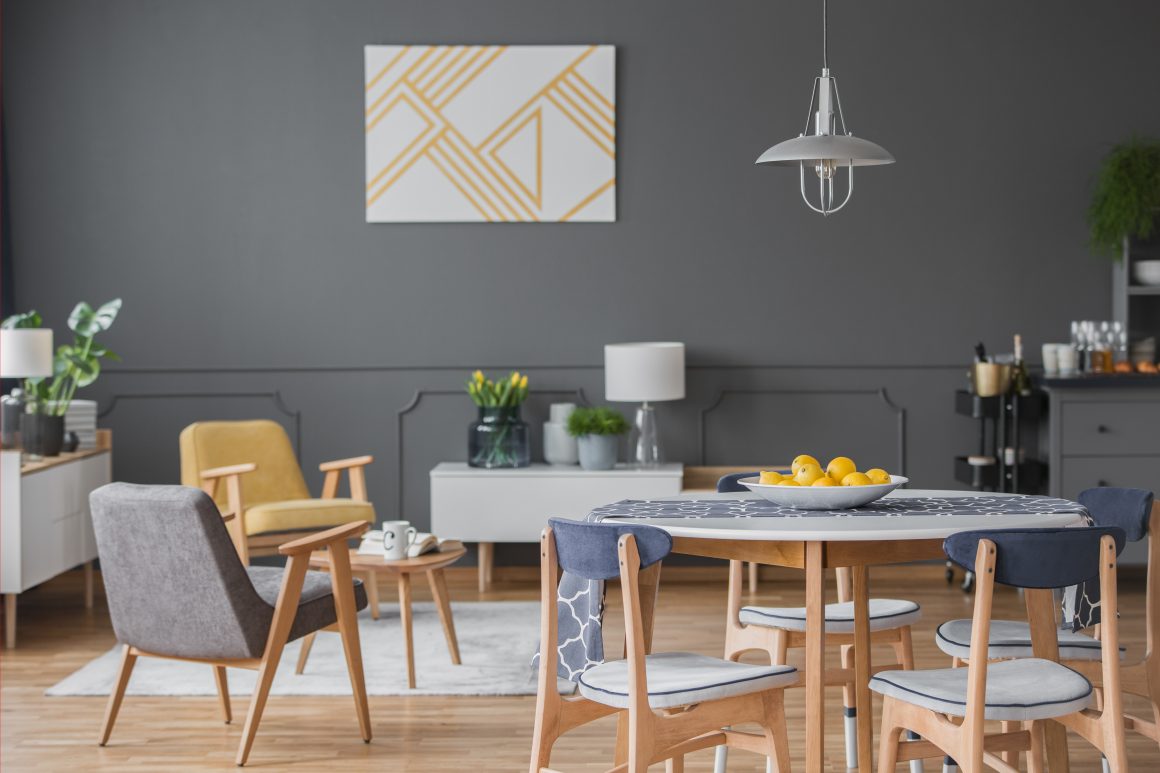 Idées de déco salle à manger et salon avec murs gris foncé, tableau minimaliste et mobilier en bois clair aux lignes arrondies.