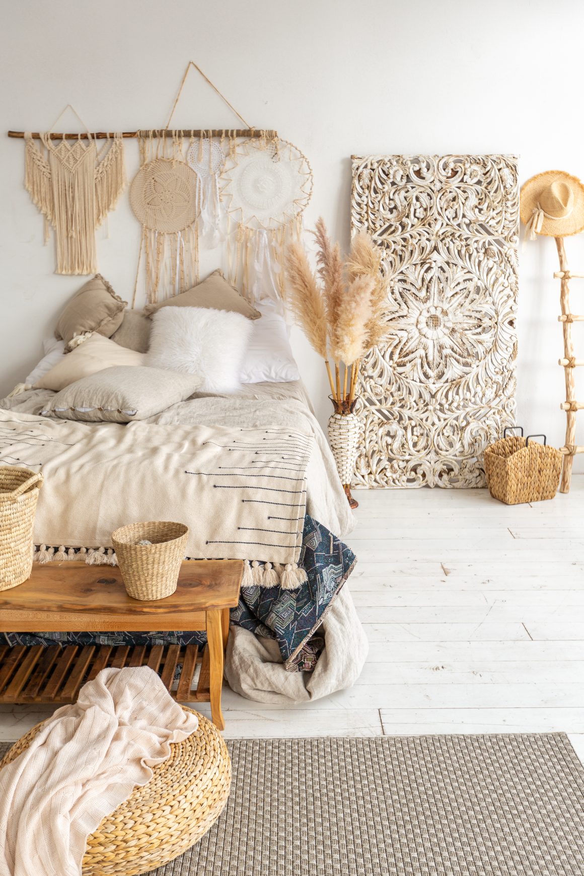 Chambre bohème avec décorations murales en macramé, accessoires tissés, paniers et plantes séchées.