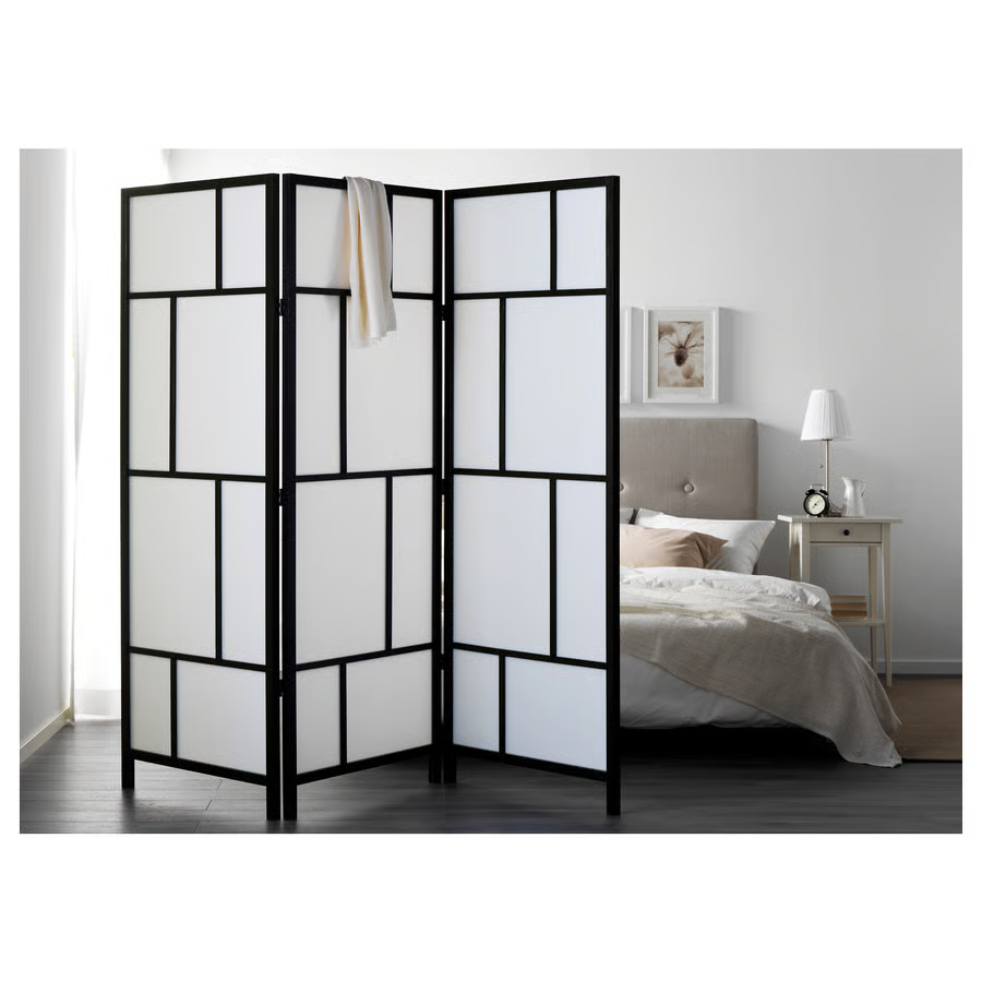 Paravent moderne noir avec panneaux blancs, séparant chambre dans un studio 30m2.