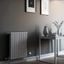 Radiateur électrique mural design dans un intérieur minimaliste incluant une table avec des objets décoratifs.