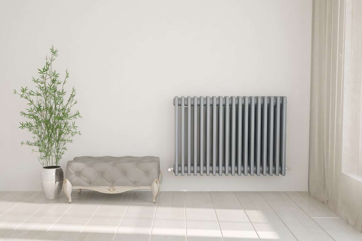 Radiateur électrique mural gris dans un espace lumineux incluant un banc en velours et une plante.