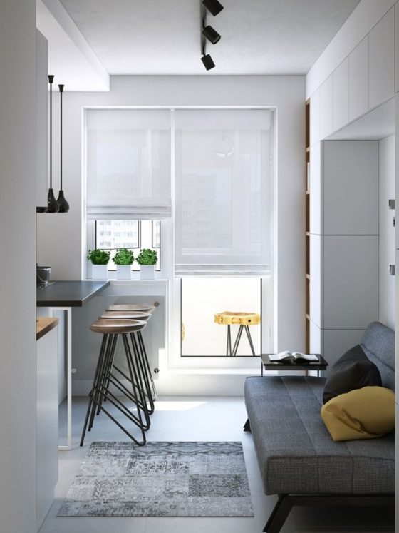 Aménagement petit studio 15m2 avec cuisine bar, tabourets, canapé convertible et rangements intégrés