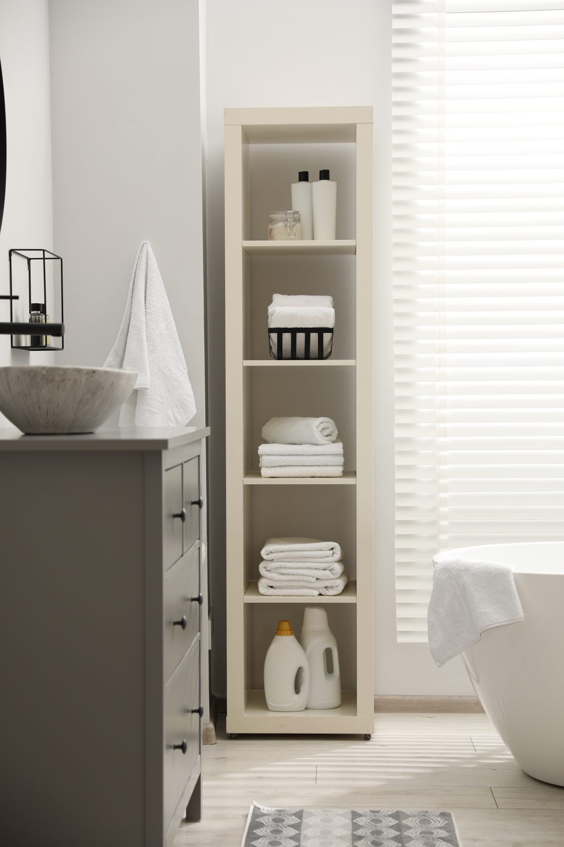 Salle de bain moderne incluant une colonne rangement ouverte avec baignoire