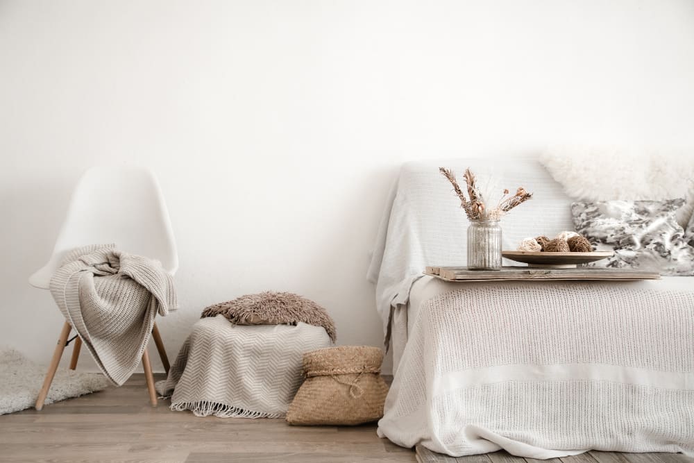 une chambre dans les tons blanc cassé avec un plateau sur le lit