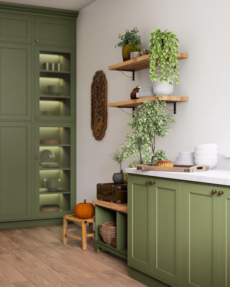 une cuisine vert sauge avec des étagères en bois au mur
