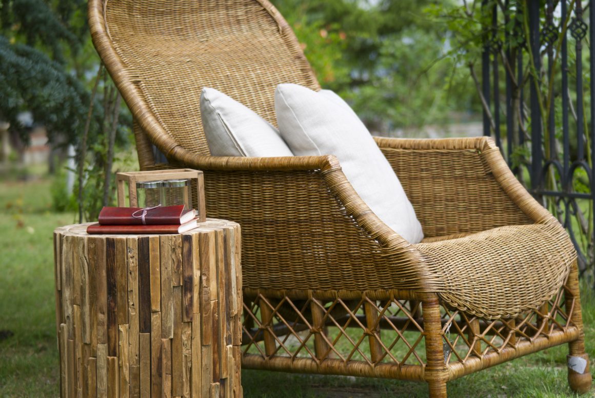Coin jardin avec fauteuil en osier et une table ronde en bois
