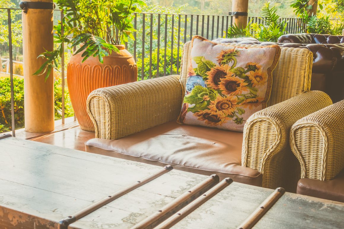 Aménagement d'un coin salon de jardin avec fauteuil en rotin et table en bois