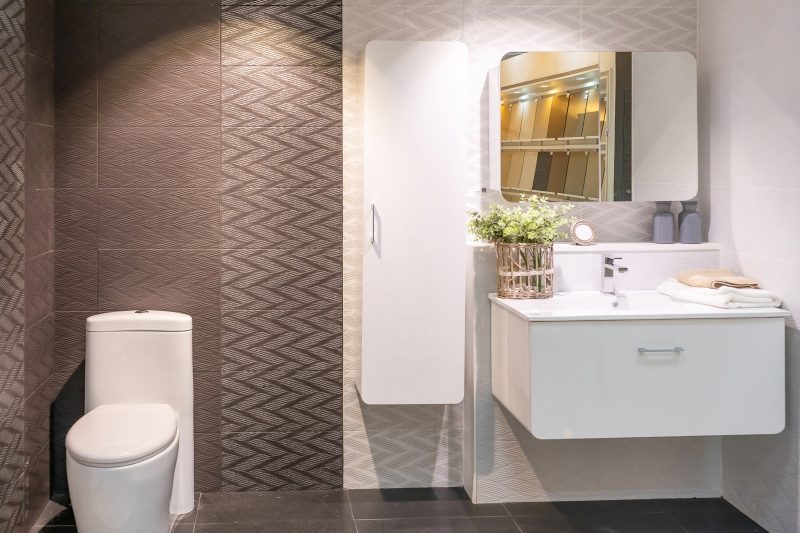 Meuble lave mains pour WC moderne avec miroir, plantes décoratives et éclairage doux.