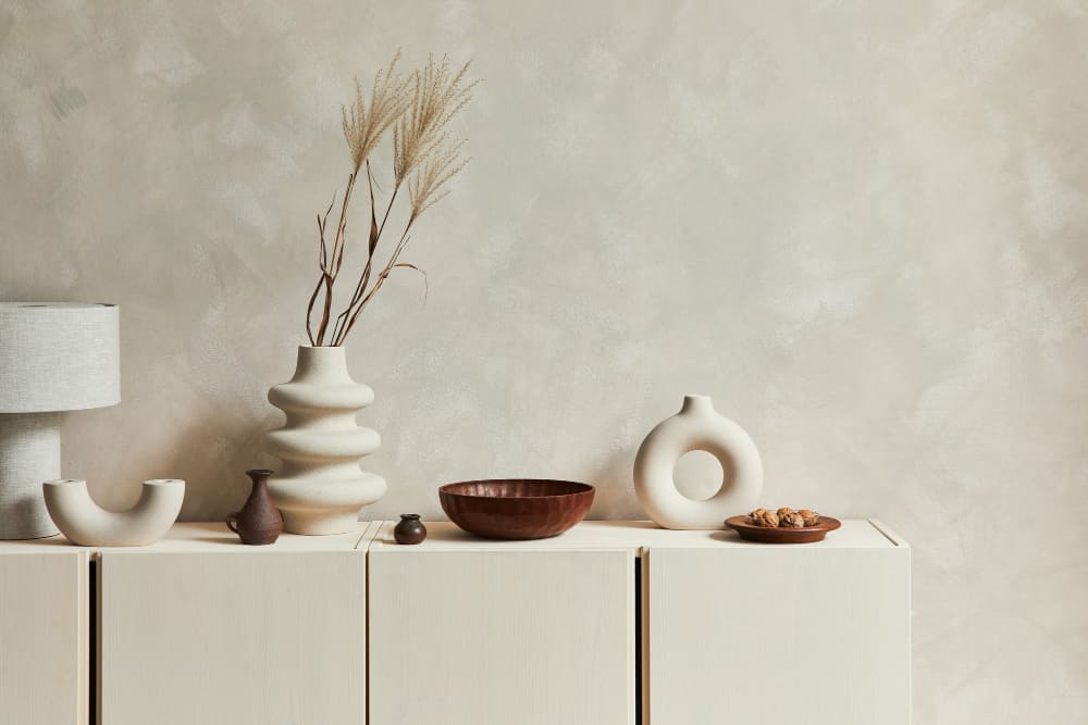 un mur couleur sable et un buffet blanc cassé avec de la déco dessus
