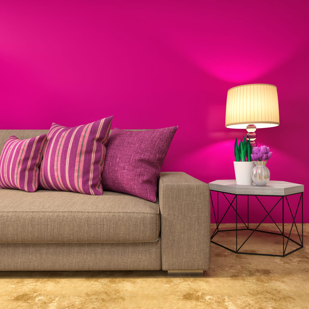 Un mur fuschia assorti aux coussins, avec un canapé beige et une lampe jaune