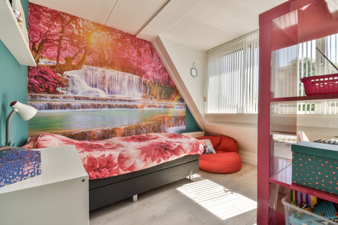 Chambre adulte avec papier peint panoramique paysage, lit, bureau, étagères et grande fenêtre