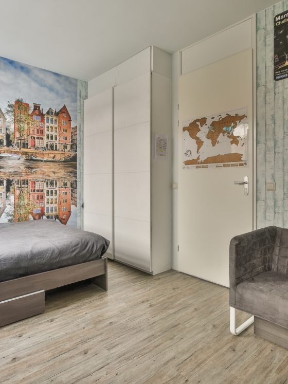 Chambre incluant un lit, un canapé, des cadres, une armoire et un papier peint panoramique paysage