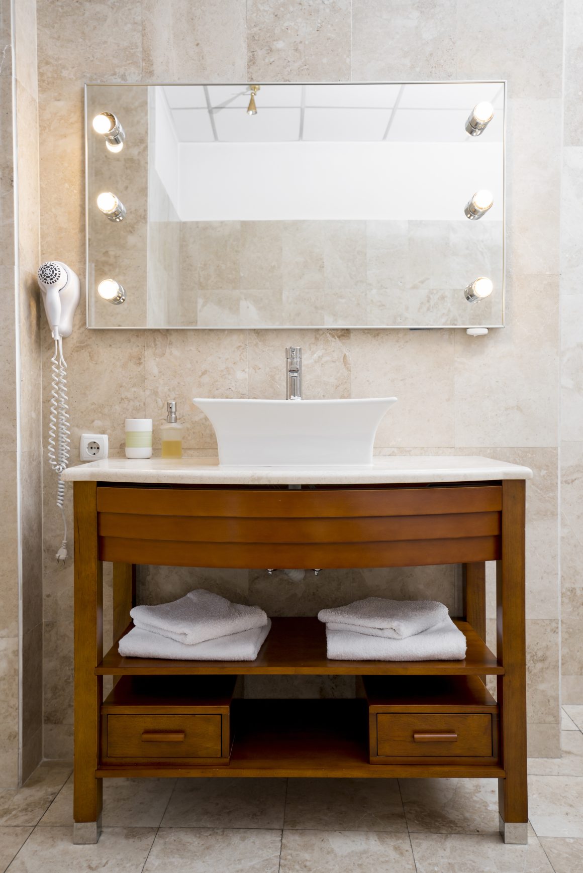 Miroir et meuble vasque incluant étagères pour ranger serviettes salle de bain.
