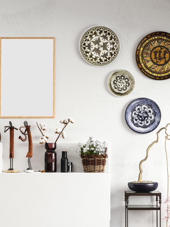 Décorer un mur blanc avec un cadre minimaliste et des assiettes décoratives variées