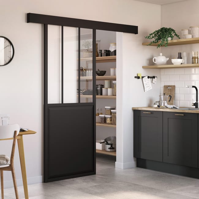 Porte coulissante noire en verre et panneau, ouverte sur cellier, dans une cuisine moderne