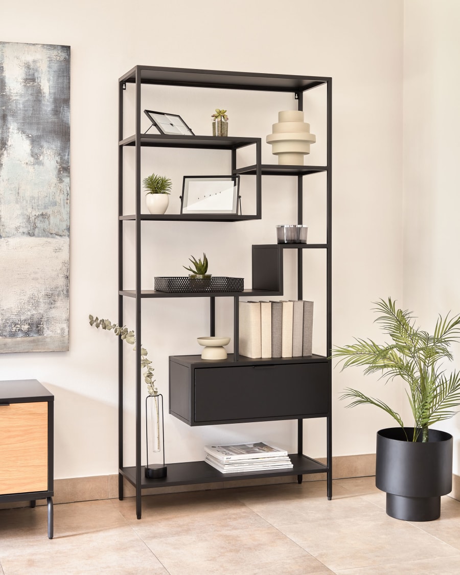 Étagère métallique noire moderne incluant objets décoratifs minimalistes, avec plante en pot et cadre mural
