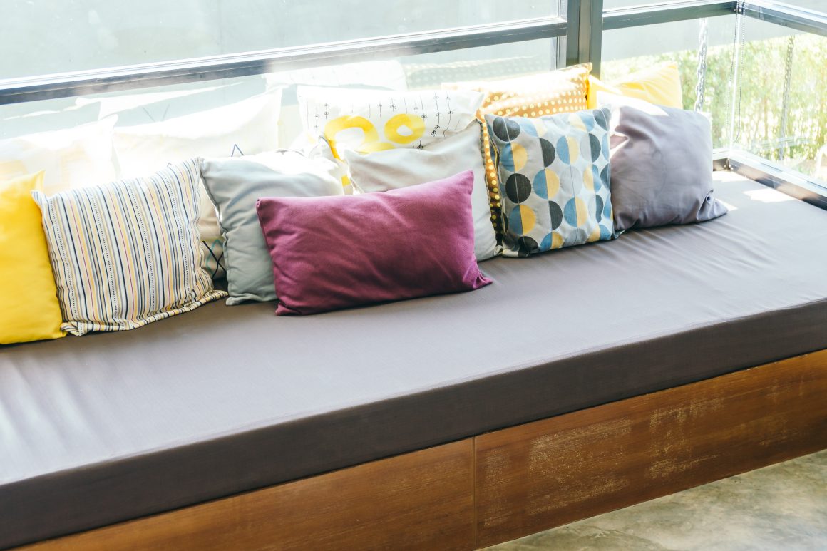 Terrasse 12m2 aménagée avec une banquette d'angle et des coussins colorés