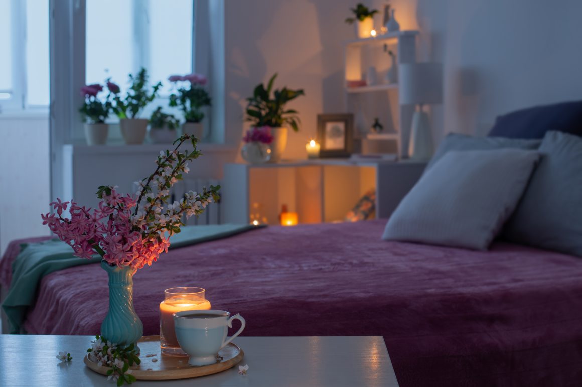 Chambre zen et apaisante avec bougies allumées, fleurs et lit rose