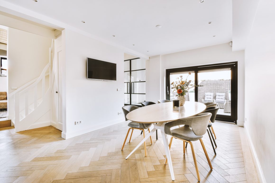Idée rénovation maison avec parquet en chevrons et grandes baies vitrées.