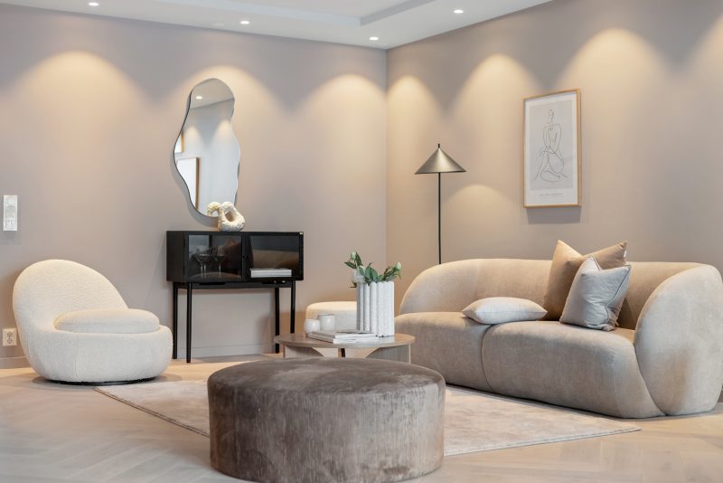 Appliques murales et lampe sur pied pour éclairer un salon incluant canapé, fauteuil, table basse et miroir