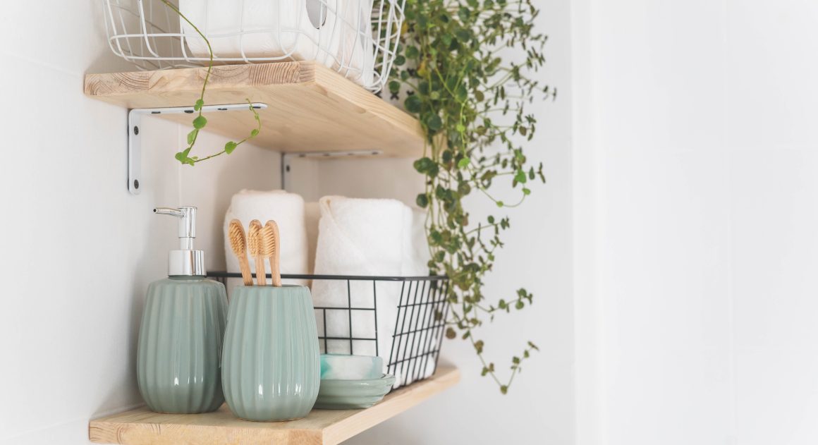 Étagères en bois minimalistes incluent des accessoires verts, serviettes blanches et une plante tombante