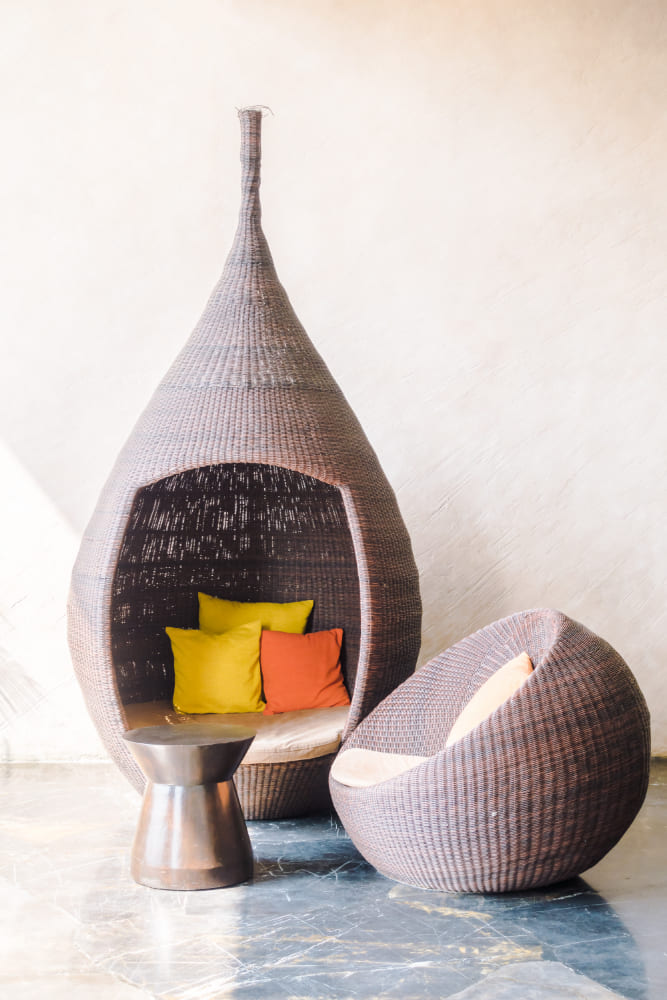 des fauteuils orignaux en rotin avec des coussins colorés