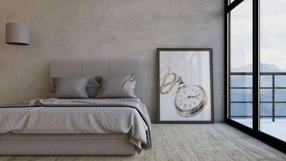 une grande chambre lumineuse avec du parquet au sol, un mur gris et des sols en bois avec une baie vitrée et un tableau moderne