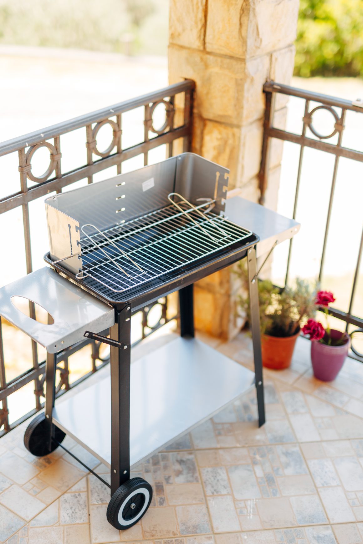 Coin barbecue dans une terrasse avec pots de fleurs