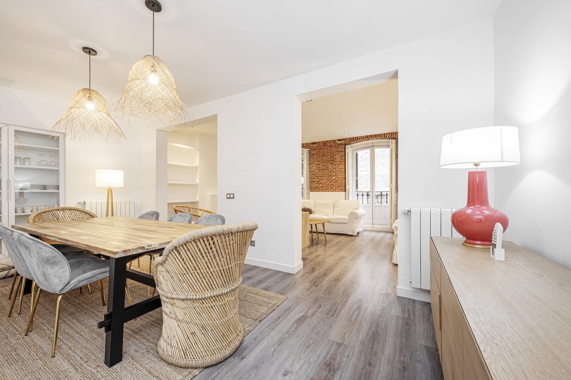 Idées rénovation maison incluant salon et salle à manger avec table en bois, chaises rotin et velours et luminaires tressés.