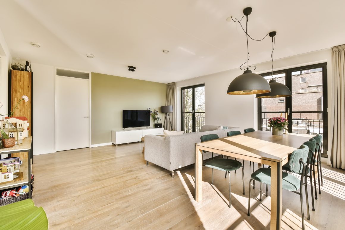 Idée rénovation maison lumineuse avec grandes fenêtres, sol en bois et luminaires suspendus