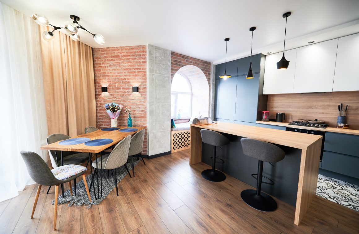 Idées rénovation maison avec espace ouvert incluant cuisine, coins repas, mur en briques et suspensions.